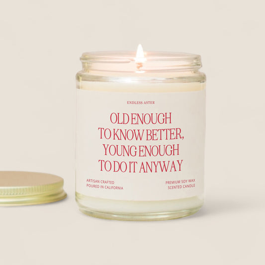 a candle with a quote on it next to a cookie